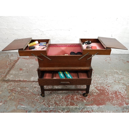 21 - A mid 20th century oak concertina sewing box on stand with single drawer and castors - approx. 58cm ... 