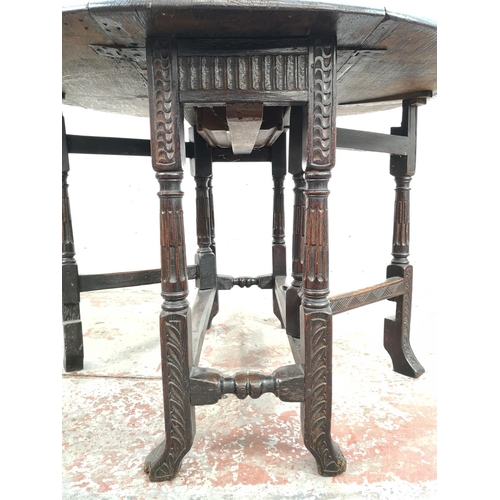 22 - A 17th century style carved oak drop leaf gate leg oval occasional table with single drawer - approx... 