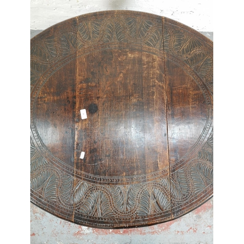 22 - A 17th century style carved oak drop leaf gate leg oval occasional table with single drawer - approx... 