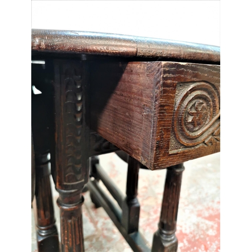 22 - A 17th century style carved oak drop leaf gate leg oval occasional table with single drawer - approx... 