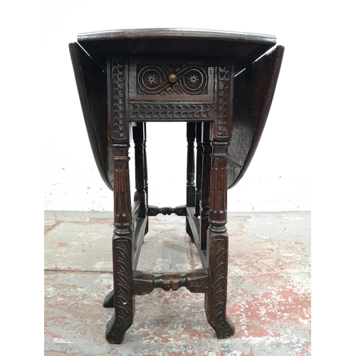 22 - A 17th century style carved oak drop leaf gate leg oval occasional table with single drawer - approx... 