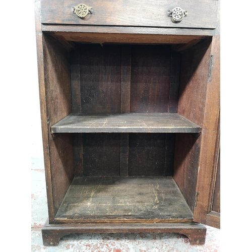 33 - An early 20th century carved oak single door cabinet with upper drawer - approx. 97cm high x 66cm wi... 