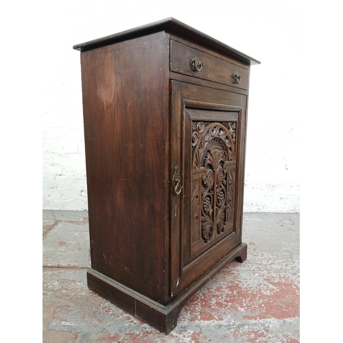 33 - An early 20th century carved oak single door cabinet with upper drawer - approx. 97cm high x 66cm wi... 