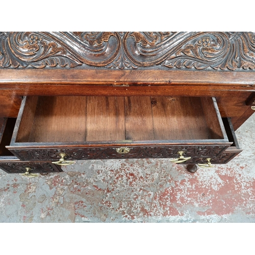 38 - A late 19th/early 20th century Macclesfield School of Carving oak writing desk with fall front, thre... 