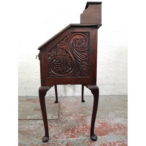 38 - A late 19th/early 20th century Macclesfield School of Carving oak writing desk with fall front, thre... 