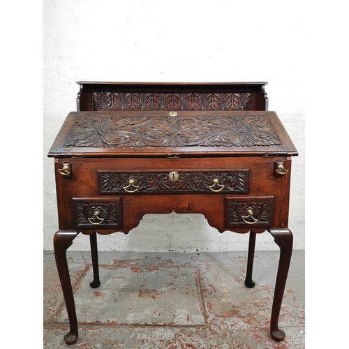 38 - A late 19th/early 20th century Macclesfield School of Carving oak writing desk with fall front, thre... 