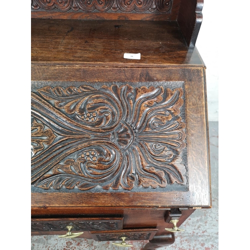 38 - A late 19th/early 20th century Macclesfield School of Carving oak writing desk with fall front, thre... 