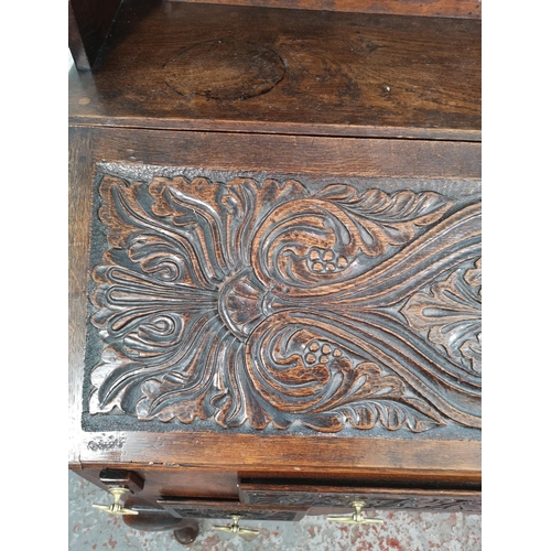 38 - A late 19th/early 20th century Macclesfield School of Carving oak writing desk with fall front, thre... 