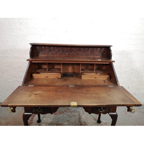 38 - A late 19th/early 20th century Macclesfield School of Carving oak writing desk with fall front, thre... 