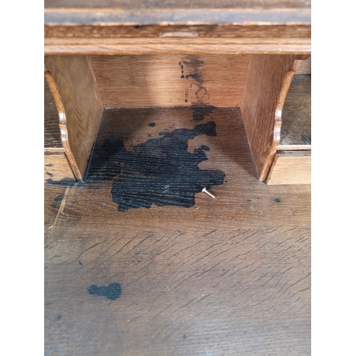 38 - A late 19th/early 20th century Macclesfield School of Carving oak writing desk with fall front, thre... 