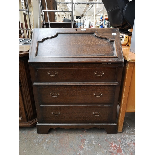 52 - Seven pieces of oak furniture to include bureau, sideboard, two drawer coffee table, magazine rack, ... 