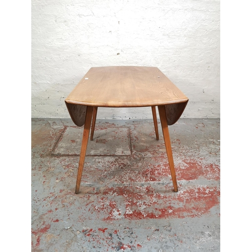 55 - An Ercol blonde elm and beech drop leaf dining table with four Ercol model 391 Windsor dining chairs... 