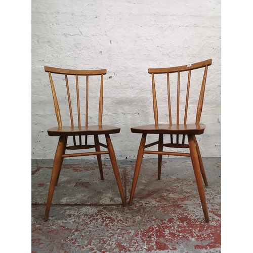 55 - An Ercol blonde elm and beech drop leaf dining table with four Ercol model 391 Windsor dining chairs... 