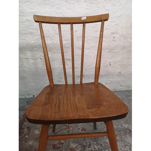 55 - An Ercol blonde elm and beech drop leaf dining table with four Ercol model 391 Windsor dining chairs... 