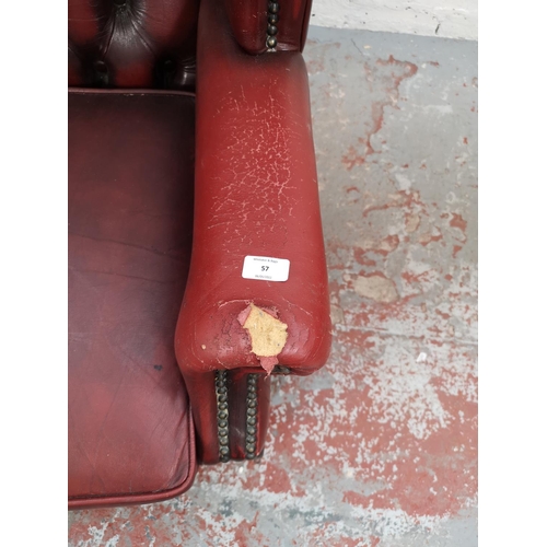 57 - An oxblood leather Chesterfield wing back armchair with cabriole supports - approx. 105cm high x 87c... 