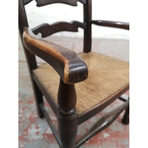 6 - A 19th century style oak ladder back child's armchair with rush seat - approx. 76cm high x 42cm wide... 