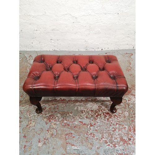 64 - A red leather Chesterfield footstool with cabriole supports - approx. 32cm high x 38cm wide x 67cm l... 