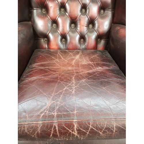 65 - An oxblood leather Chesterfield wing back armchair - approx. 112cm high x 77cm wide x 77cm deep