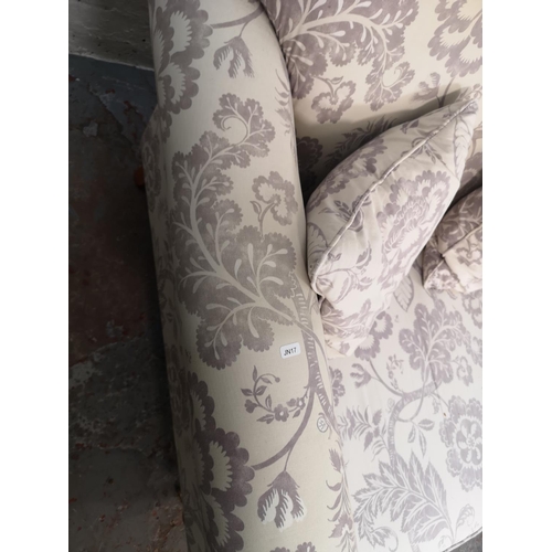 92 - A Wesley Barrell white and purple floral upholstered three seater sofa with castors - approx. 93cm h... 