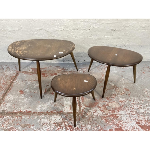 80 - An Ercol dark elm and beech pebble shaped nest of three tables