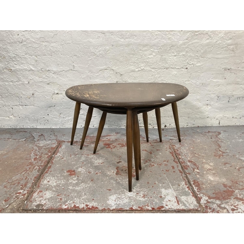 80 - An Ercol dark elm and beech pebble shaped nest of three tables