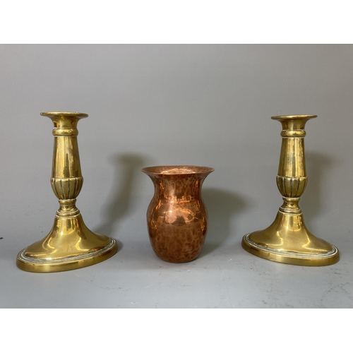 63 - A collection of copper and brassware to include a pair of 16cm candlesticks, kettle, ashtrays etc.