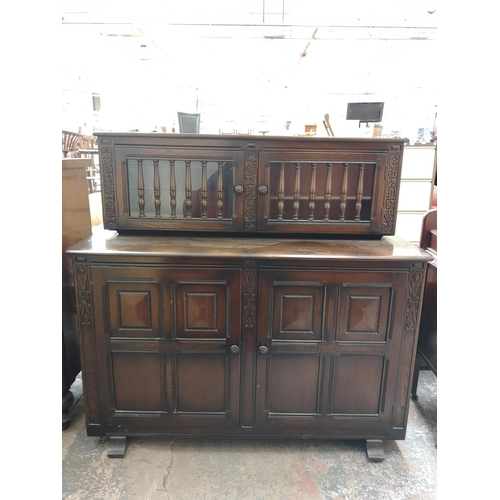 423B - An Ercol dark elm and beech court cupboard with two upper glazed doors and two lower cupboard doors ... 