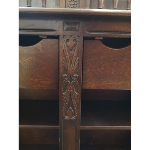 423B - An Ercol dark elm and beech court cupboard with two upper glazed doors and two lower cupboard doors ... 