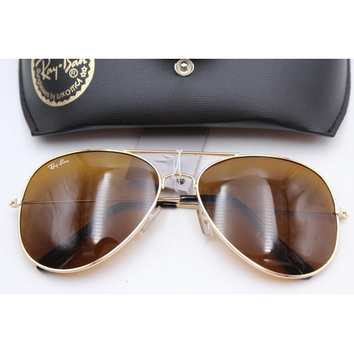 134 - A cased pair of unisex Ray-Ban gold tone aviator sunglasses