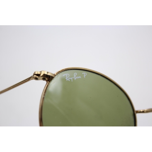 138 - A cased pair of classic Ray-Ban gold tone round metal sunglasses with polarized lenses