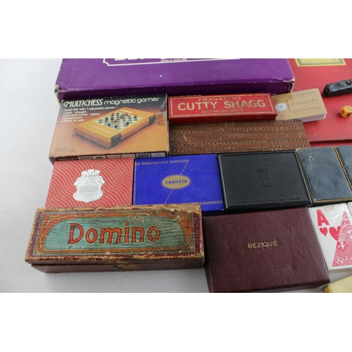 69 - A collection of assorted playing cards and games to include cribbage, dice, dominoes etc.