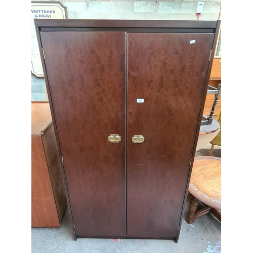 415 - A vintage mahogany double wardrobe with brass handles, internal mirror, four internal shelves and cl... 