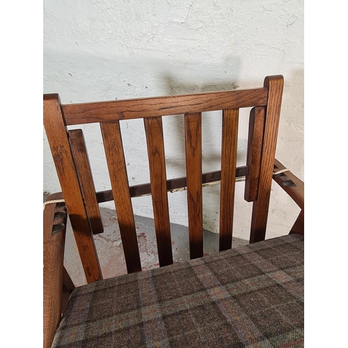 417 - An early/mid 20th century oak framed reclining armchair with tartan upholstery