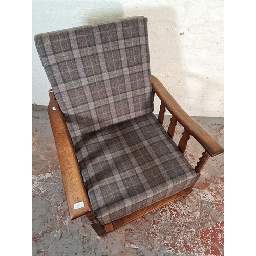 417 - An early/mid 20th century oak framed reclining armchair with tartan upholstery