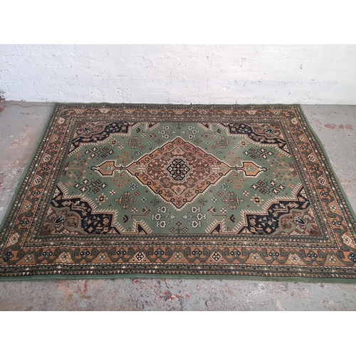 421 - A vintage green and beige rug - approx. 221cm x 159cm