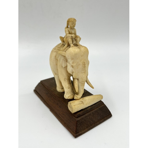 An antique carved ivory elephant and rider figurine with wooden base ...