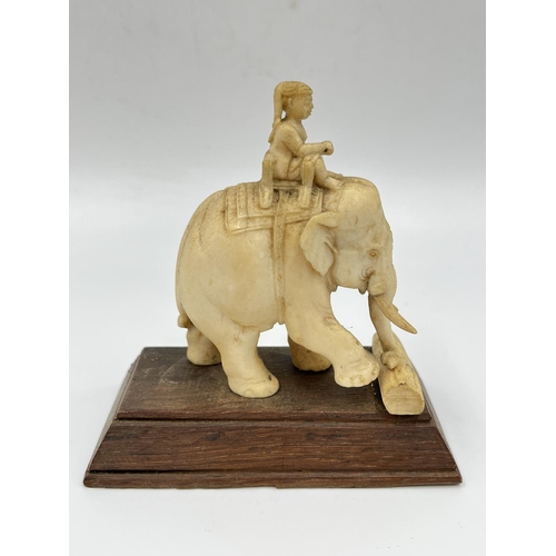 An antique carved ivory elephant and rider figurine with wooden base ...