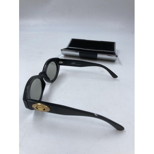 129 - A pair of Gianni Versace MOD. 480H COL.852 lady's black framed oval sunglasses