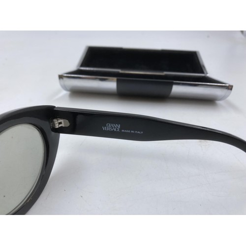 129 - A pair of Gianni Versace MOD. 480H COL.852 lady's black framed oval sunglasses