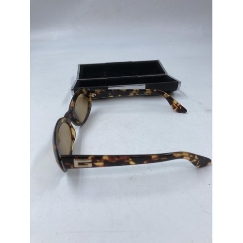 130 - Two pairs of lady's sunglasses, one Gucci tortoiseshell effect framed oval and one cased Emilio Pooc... 