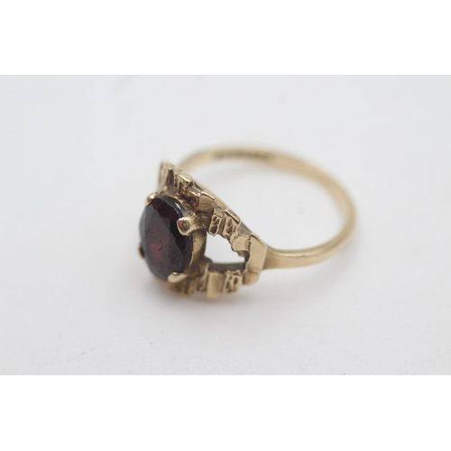 2046 - A 9ct gold garnet tree bark texture ring, size P - approx. gross weight 3.2 grams