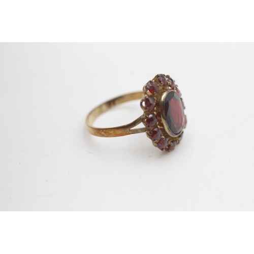 2101 - An 8ct gold garnet halo ring ,size O - approx. gross weight 3 grams