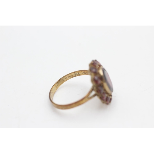 2101 - An 8ct gold garnet halo ring ,size O - approx. gross weight 3 grams