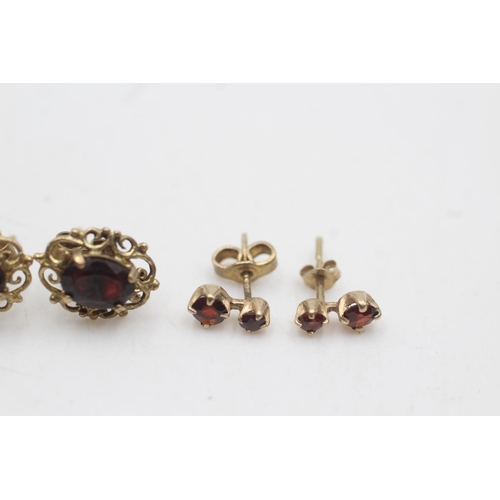 2149 - Two pairs of 9ct gold garnet ornate stud earrings - approx. gross weight 2.3 grams