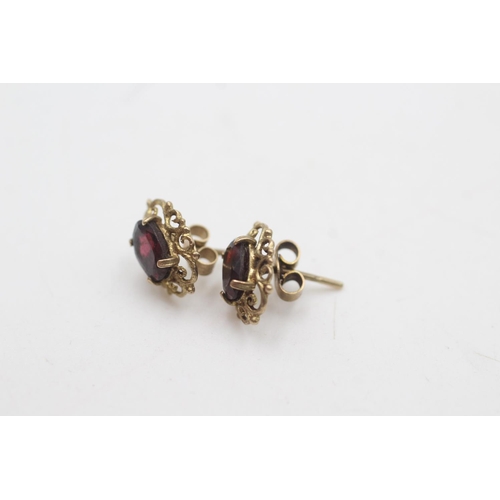 2149 - Two pairs of 9ct gold garnet ornate stud earrings - approx. gross weight 2.3 grams