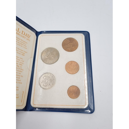 75 - A collection of assorted cased coins to include Coronation crowns, Britain's First decimal coin set ... 