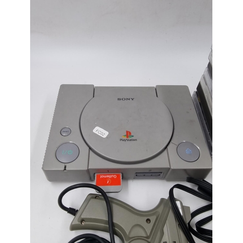 1522 - A Sony PlayStation console with accessories and games to include Gran Turismo, Tekken 2, Crash Bandi... 