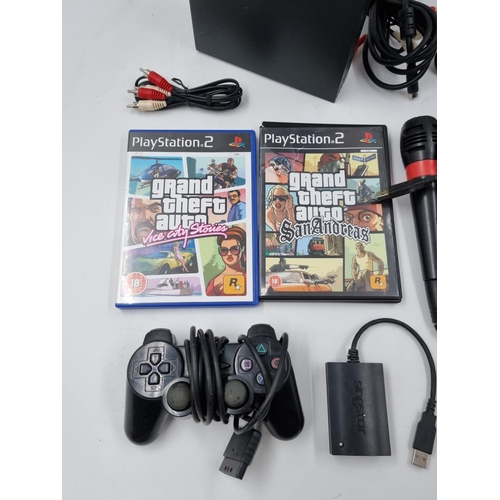 1512 - A PlayStation 2 console with two Grand Theft Auto games and accessories