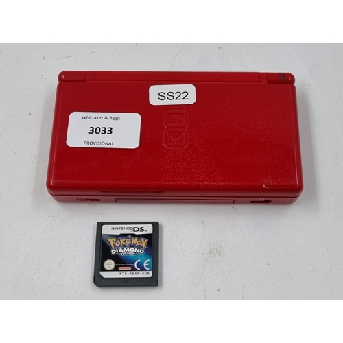 1506 - A red Nintendo DS lite hand held console with Pokémon Diamond version game