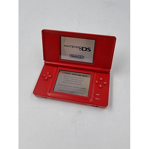 1506 - A red Nintendo DS lite hand held console with Pokémon Diamond version game